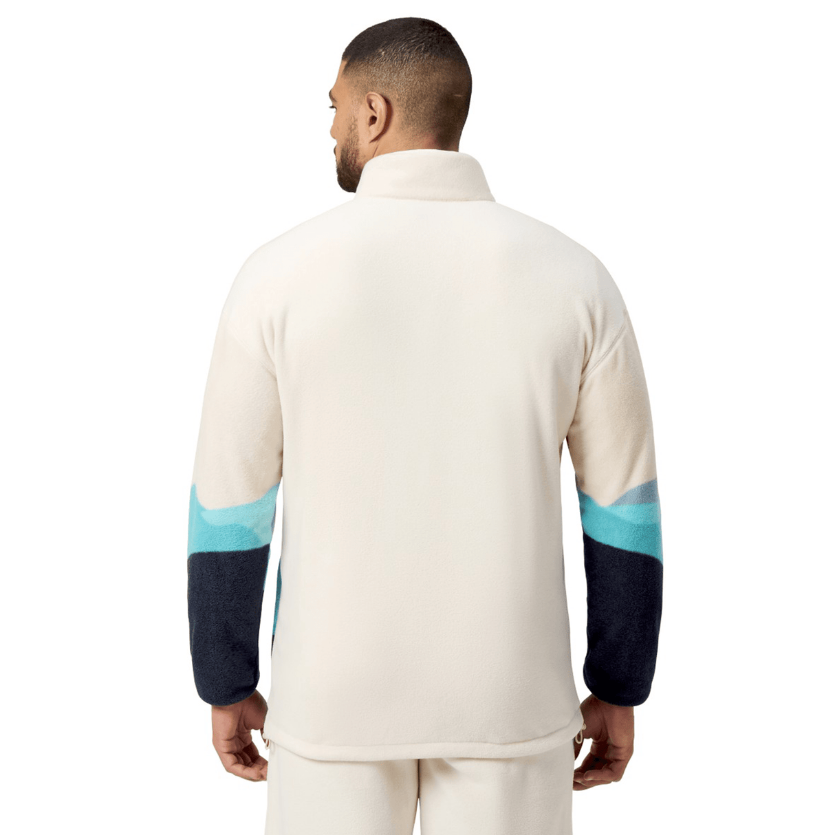 A person wearing the British & Irish Lions 2025 Outback Full-Zip Fleece Jacket by Canterbury is shown from the back, highlighting its dark blue sleeves with light blue accents that embody the adventurous spirit of exploration.