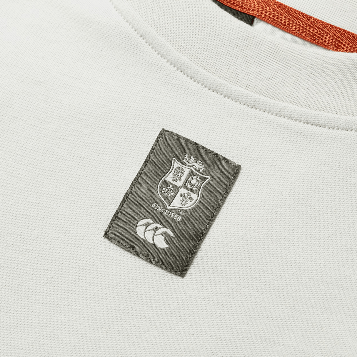 A detailed view of the British & Irish Lions 25 Outback Long Sleeve Tee by Canterbury showcases a logo patch with a shield design, featuring the text "Since 1888" and a stylized emblem below. This white tee embodies the essence of the British & Irish Lions and is crafted to meet Canterbury's high-quality standards.
