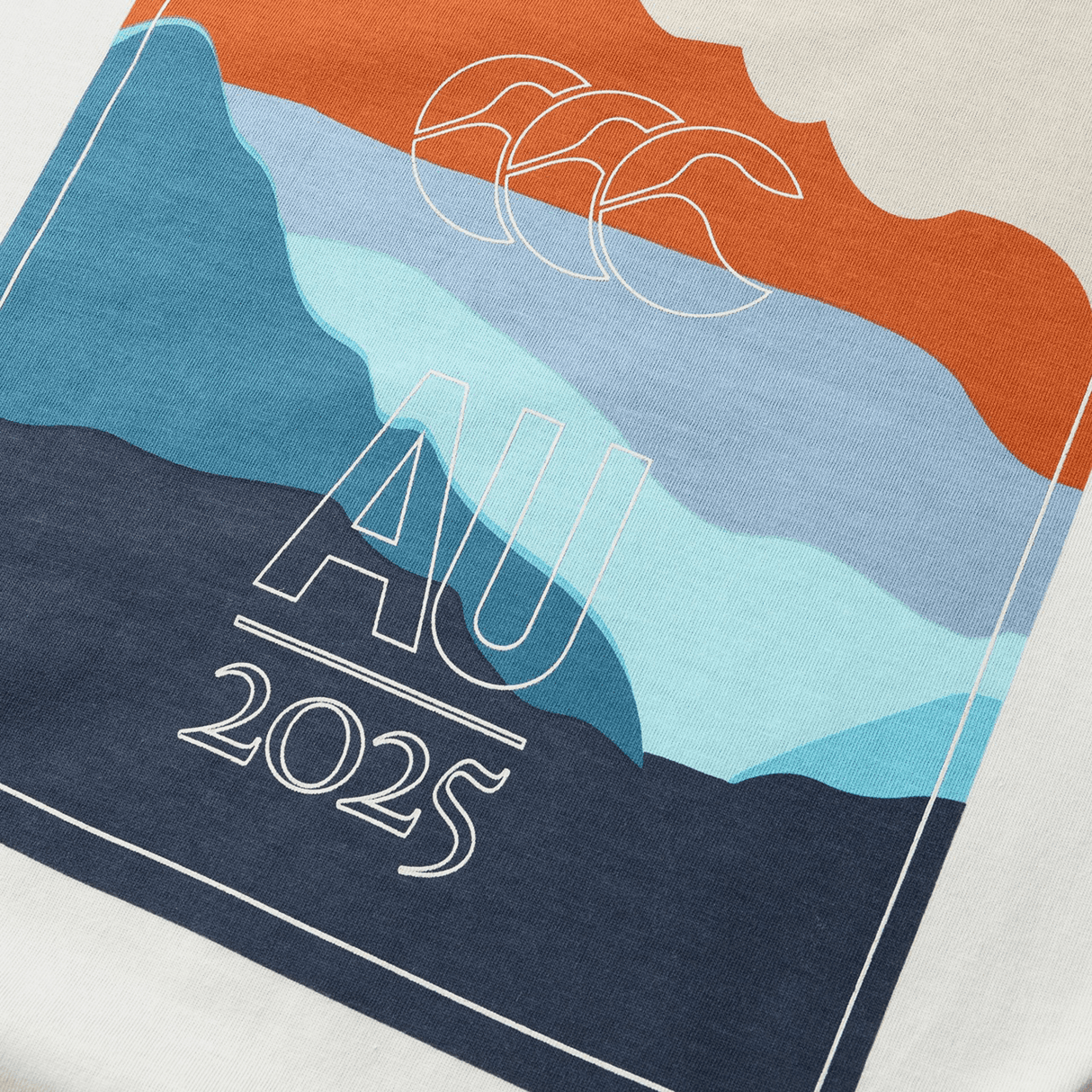 The British & Irish Lions 25 Outback Long Sleeve Tee by Canterbury features an abstract design on fabric with overlapping mountain shapes in orange, blue, and navy hues. The top is labeled "AU 2025" and "CCC," capturing the spirit of adventure.
