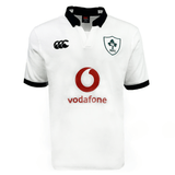 The Ireland 24 Alternate Classic Jersey by Canterbury features a white design with the Ireland Rugby Football Union (IRFU) logo on the left chest, a red Vodafone logo in the center, and a black collar and cuffs. This jersey is crafted using Canterbury's VapoDri technology for optimal performance.
