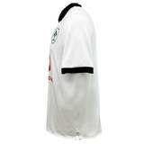 Side view of the lightweight white Ireland 24 Alternate Classic Jersey by Canterbury, showcasing a black collar and sleeve trim. The jersey features a team logo on the chest with a red sponsor logo beneath it, and incorporates VapoDri technology by Canterbury for enhanced comfort.
