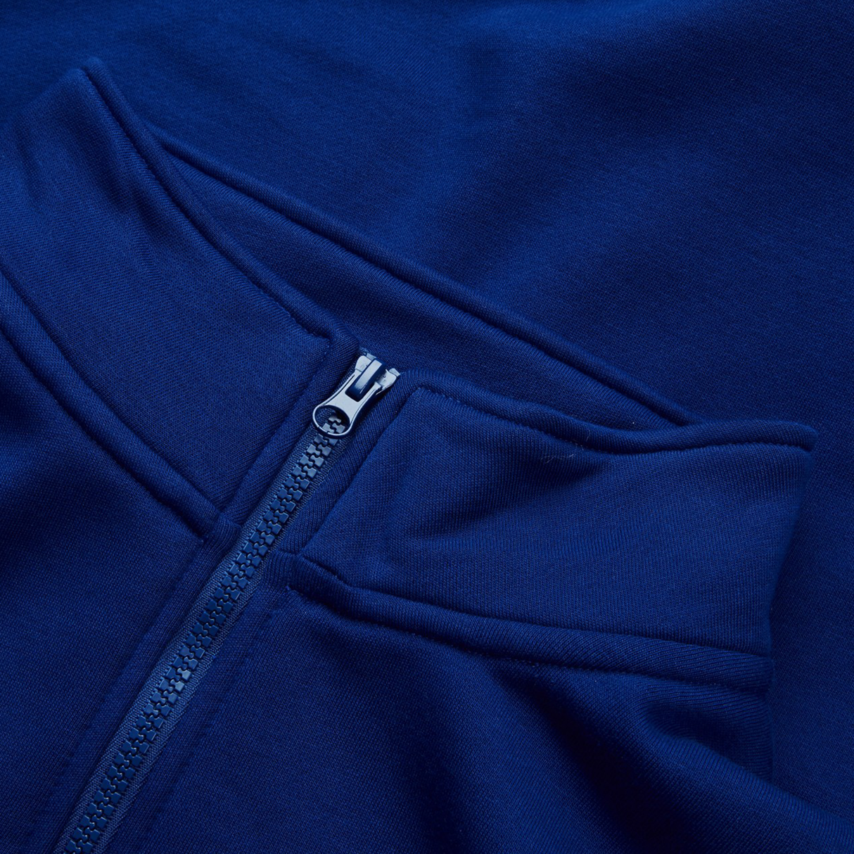 Close-up of a blue fabric with front zipper and seam detail, echoing the classic Canterbury Sport Dept 1/4 Zip Pullover design.