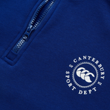 Close-up of a blue Canterbury Sport Dept 1/4 Zip Pullover featuring a circular logo with three kiwis and "Canterbury Sport Dept N.Z." It boasts rib-knit cuffs for comfort, making it perfect for athletic or casual wear.