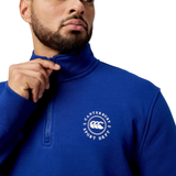 Person in a blue Canterbury Sport Dept 1/4 Zip Pullover adjusts the zipper of their stylish pullover featuring rib-knit cuffs.