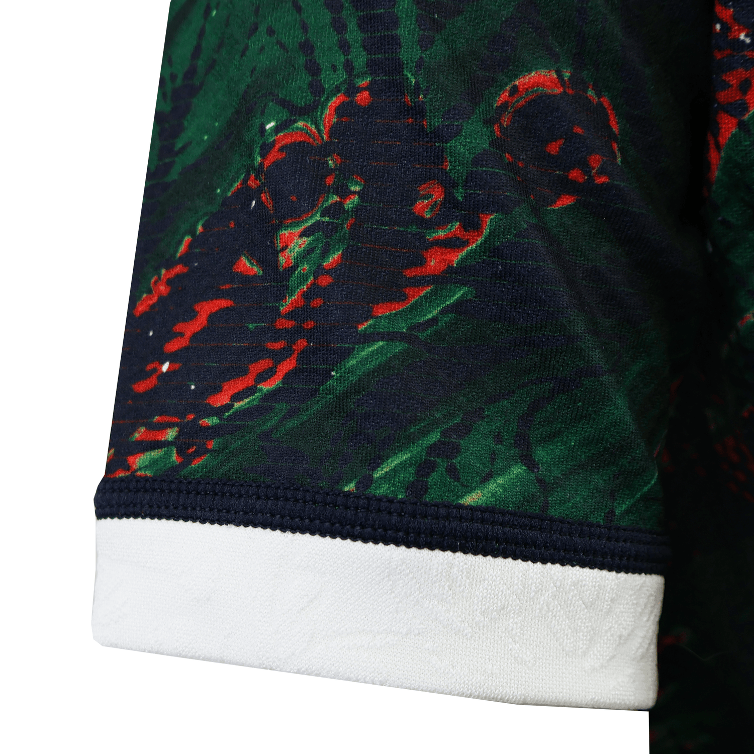 Close-up of a British & Irish Lions 2025 Warm Up Jersey sleeve, in dark green and red patterns with a white cuff, made from moisture-wicking fabric by Canterbury.