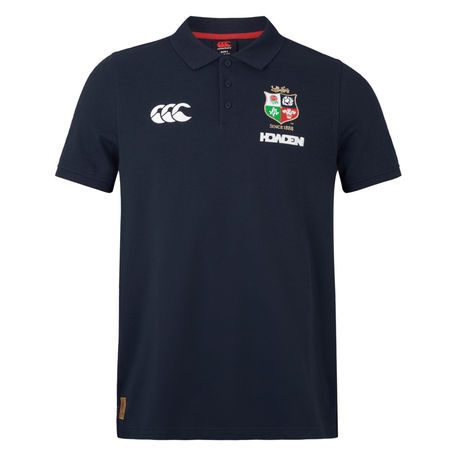 The British & Irish Lions 25 Pique Polo by Canterbury is a navy blue pique polo shirt featuring embroidered logos on the chest, including a lion emblem symbolic of the British & Irish Lions and Canterbury’s signature brand insignia, complemented by a small tag at the bottom.