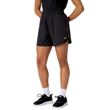 A person wearing a black t-shirt, Canterbury Women's Tempo+ 5" Training Shorts, white socks, and black sneakers stands against a white background.