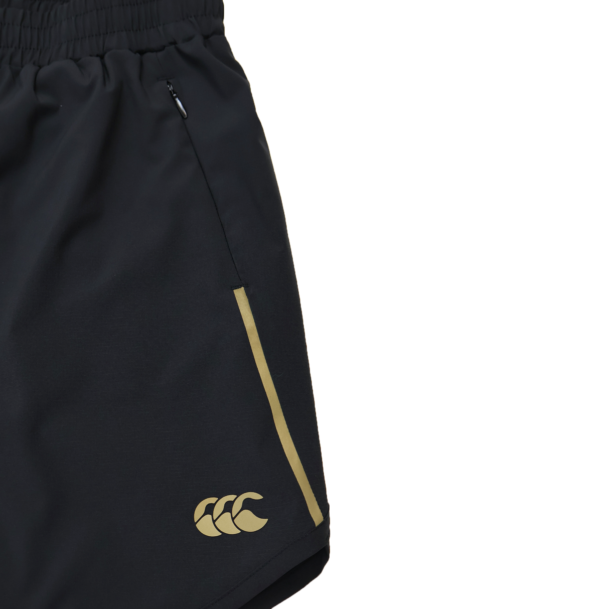 Close-up of Canterbury Women's Tempo+ 5" Training Shorts in black, featuring a yellow logo and side stripe, elastic waistband, zippered pocket, and moisture-wicking fabric for comfort.