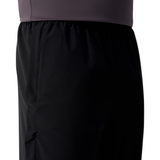 Close-up of a person wearing the Canterbury Tempo+ 32" Trackpant and a dark purple or gray textured shirt, showing only the waist and upper thigh area.