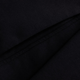 Close-up of the black Tempo+ Hoodie by Canterbury, showcasing its fabric and a diagonal seam detail.
