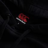 Close-up of the Canterbury Tempo+ Hoodie in black with matching drawstrings, featuring the red Canterbury logo and brand name on the inside collar.
