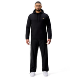 A man stands facing forward wearing the black Tempo+ Hoodie by Canterbury and black pants with white sneakers against a plain white background.
