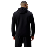 A man faces away, wearing the black Tempo+ Hoodie by Canterbury and black pants against a plain white background.