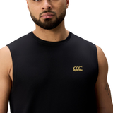A man stands against a white background wearing the Canterbury Tempo+ Training Tank, a sleeveless black top featuring a gold logo on the left chest.