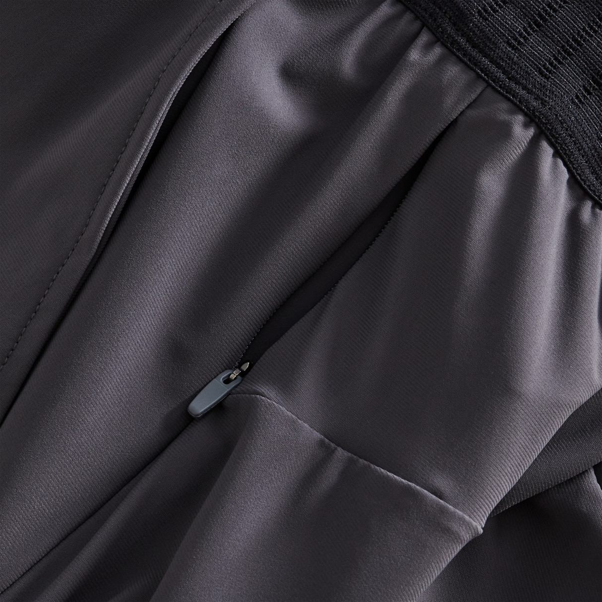 Close-up of black Canterbury Everest Woven Pants showcasing a visible zipper and gathered stitching, perfect for performance training or rugby.