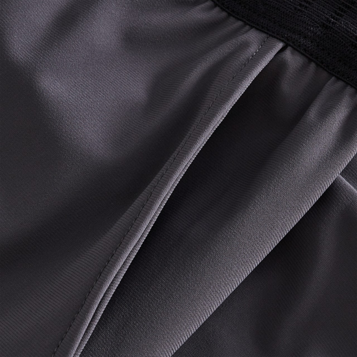 Close-up of a pocket on dark gray Canterbury Everest Woven Pants with an elastic waistband, designed for performance training.