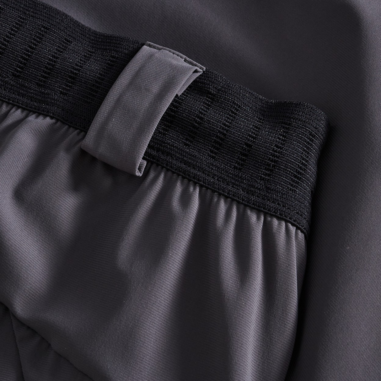 Close-up of Canterbury Everest Woven Pants in grey, featuring a performance design with an elastic waistband and belt loop detail.