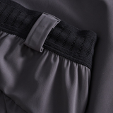 Close-up of Canterbury Everest Woven Pants in grey, featuring a performance design with an elastic waistband and belt loop detail.