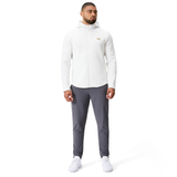 A man faces forward wearing the Canterbury Everest Training Full-Zip Hoodie in white, styled with gray pants and white sneakers, set against a plain white background.