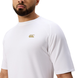 A man with a beard wears the Everest Training Tee by Canterbury—a plain white short-sleeve rugby training shirt featuring Canterbury’s gold logo on the chest.