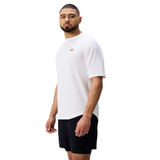 A man stands facing slightly left, wearing the Everest Training Tee by Canterbury with black shorts, against a white background.