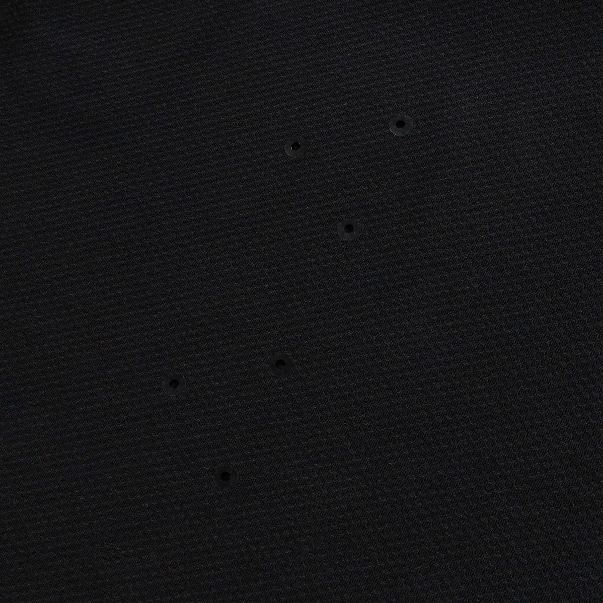 The Everest Training Tee by Canterbury features black textured fabric with six small, evenly spaced holes for breathability—a performance fit designed especially for rugby players.