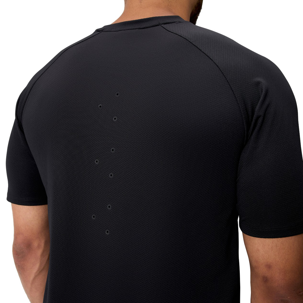 A person wearing the Everest Training Tee by Canterbury, a black short-sleeve athletic shirt with upper back ventilation holes for a performance fit preferred by rugby players.