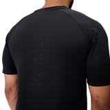 A person wearing the Everest Training Tee by Canterbury, a black short-sleeve athletic shirt with upper back ventilation holes for a performance fit preferred by rugby players.