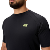 A person wearing the black Everest Training Tee by Canterbury, featuring a yellow Canterbury logo on the chest, designed for rugby players who want a performance fit.