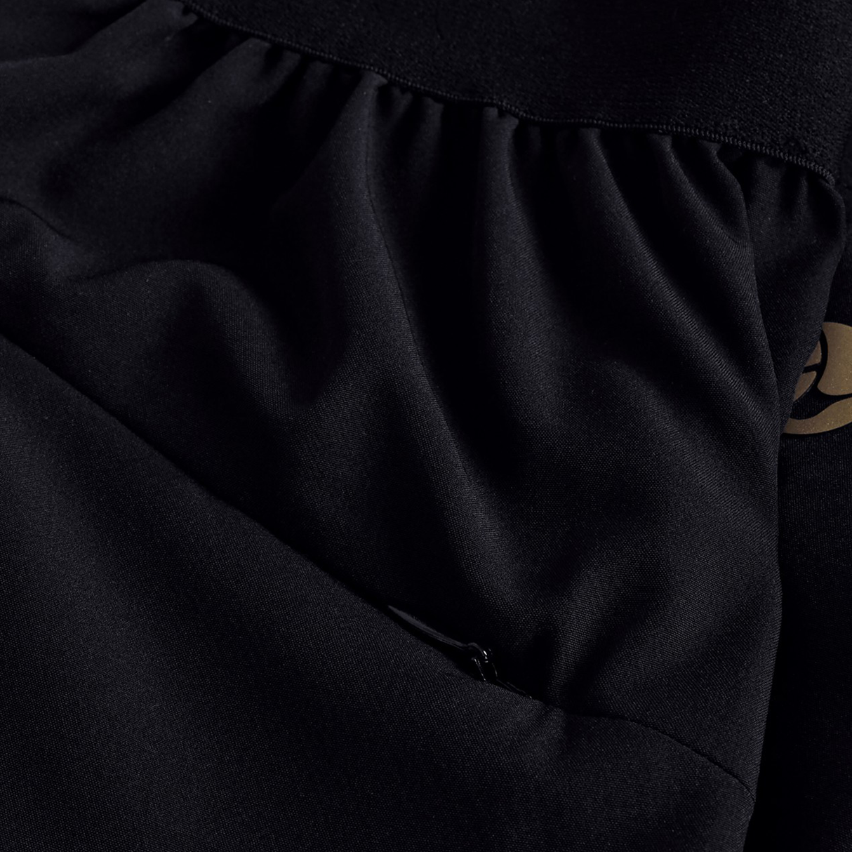 Close-up of Canterbury Tempo+ 7" Training Short in black, featuring gathered stitching and a partial gold print on the right side, highlighting quality details from Canterbury.