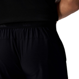 A close-up of a person wearing Canterbury Tempo+ 7" Training Shorts and a black shirt, highlighting the waistband and upper leg area from behind.