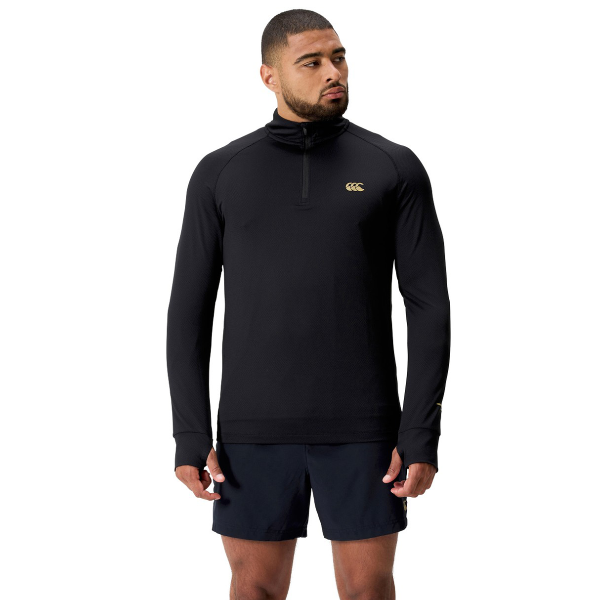 A man faces forward wearing the Canterbury Tempo+ 1/4 Zip Training Top and black shorts against a plain white background.