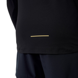Someone wears a Canterbury Tempo+ 1/4 Zip Training Top in black with a small horizontal beige line near the hem, paired with black shorts. The upper body is mostly out of frame.