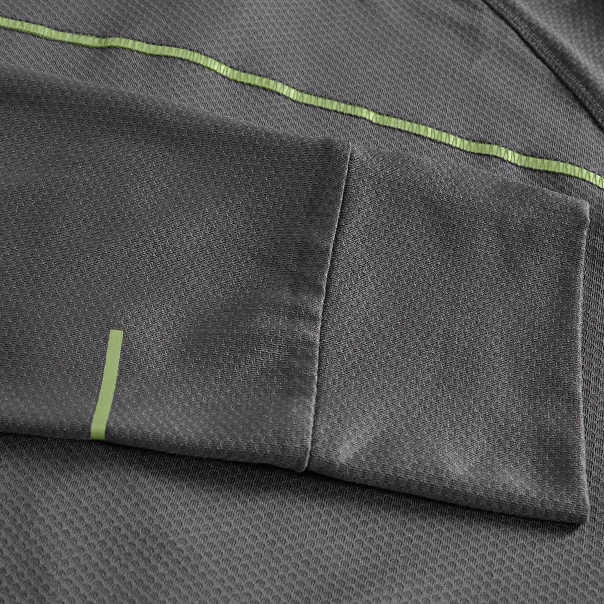 Close-up of the Canterbury Tempo+ 1/4 Zip Training Top in gray, showcasing a textured fabric, pocket detail, and light green stripe accents.
