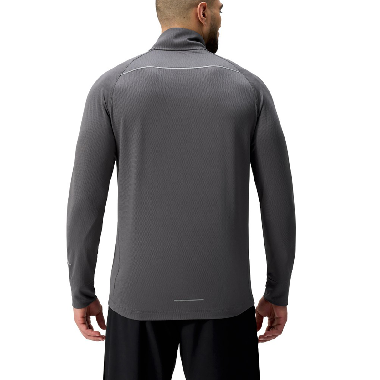 A man faces away wearing the Canterbury Tempo+ 1/4 Zip Training Top in dark gray with black shorts, set against a plain white background.