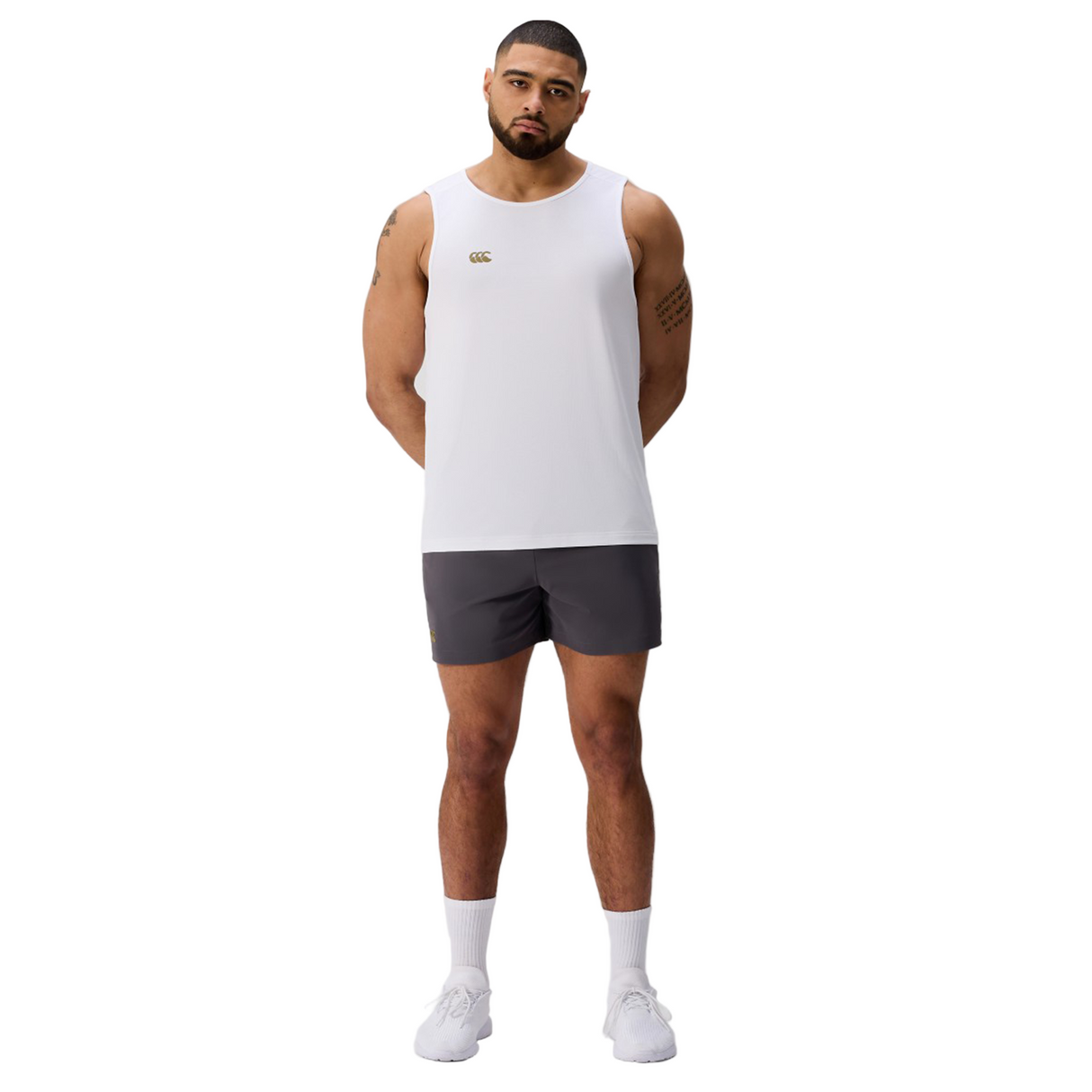 A man faces forward against a plain light background, wearing the Canterbury Tempo+ Singlet, dark athletic shorts, white socks, and white shoes.