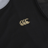 Close-up of the Tempo+ Singlet by Canterbury, a black rugby training top with a gold Canterbury logo on textured, moisture-wicking fabric for breathable performance.