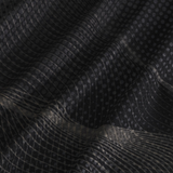 Close-up of black, moisture-wicking fabric with a grid and dot pattern, showing soft folds and subtle reflections—perfect for the Canterbury Tempo+ Singlet.