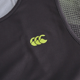 Close-up of the Canterbury Tempo+ Singlet, a dark moisture-wicking gym top featuring a yellow three-wave logo on the chest and mesh fabric detailing on the sides and top.