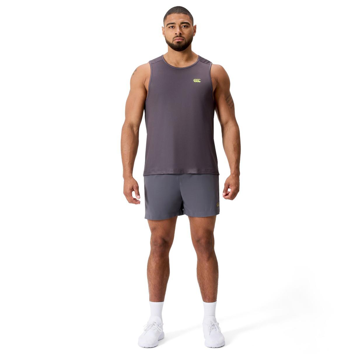 A man stands facing forward wearing the Canterbury Tempo+ Singlet, matching shorts, and white sneakers against a plain white background.