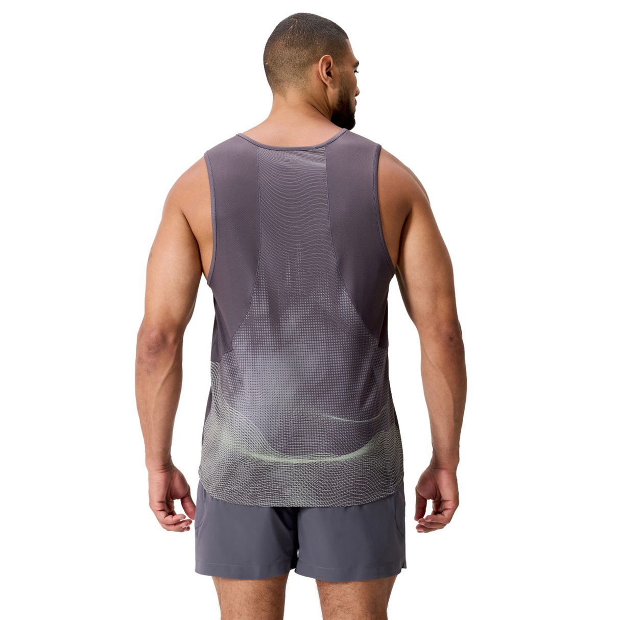 A man faces away, wearing the gray Canterbury Tempo+ Singlet and matching shorts made from moisture-wicking performance fabric, set against a white background.