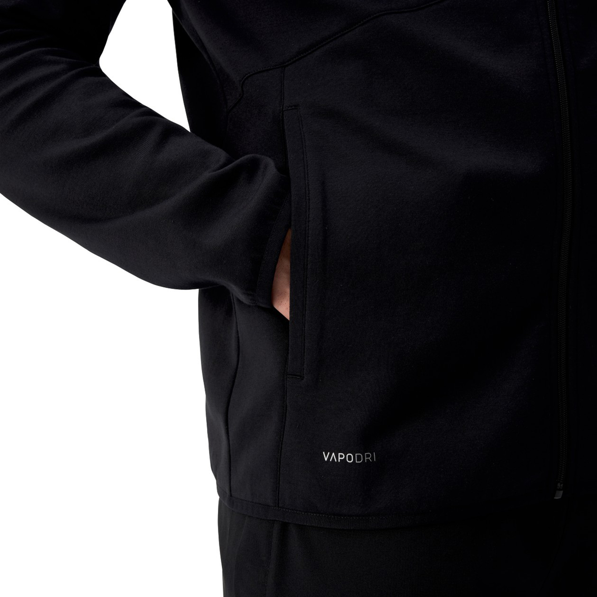 Close-up of a person wearing the Canterbury Tempo+ Full-Zip Hoodie in black, with their hand in the pocket. "VAPODRI" text is near the hem—ideal as a rugby warm-up hoodie by Canterbury.