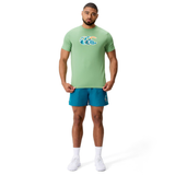 Man against white background wears a light green Canterbury Uglies CCC Logo T-Shirt by Canterbury H225, teal shorts, white socks, and white sneakers.