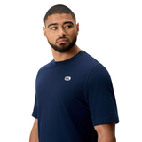 A man with short hair and a beard wears the Sport Dept. Logo T-Shirt by Canterbury, an athletic navy tee with a small white chest logo, standing against a plain white background.
