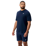 A man wearing the Canterbury Sport Dept. Logo T-Shirt and matching navy shorts, both featuring small white logos, stands against a plain white background.