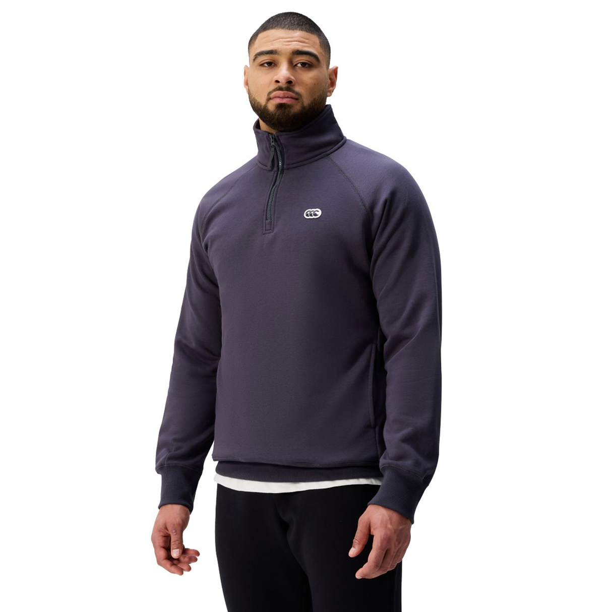 A man stands facing forward against a plain white background wearing the Sport Dept. 1/4 Zip Sweater by Canterbury and black pants, highlighting Canterbury’s classic Sport Dept style.