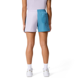A person is shown from the back against a plain white background wearing Canterbury Women's Fundamentals 3" Harletic Shorts in light purple and teal, paired with white socks and white shoes.