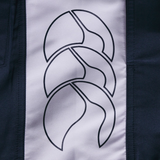 A close-up of a fabric panel from Canterbury’s Women's Fundamentals 5" Panel Tactic Shorts, showcasing three overlapping abstract lines with bold dark and light color contrast.