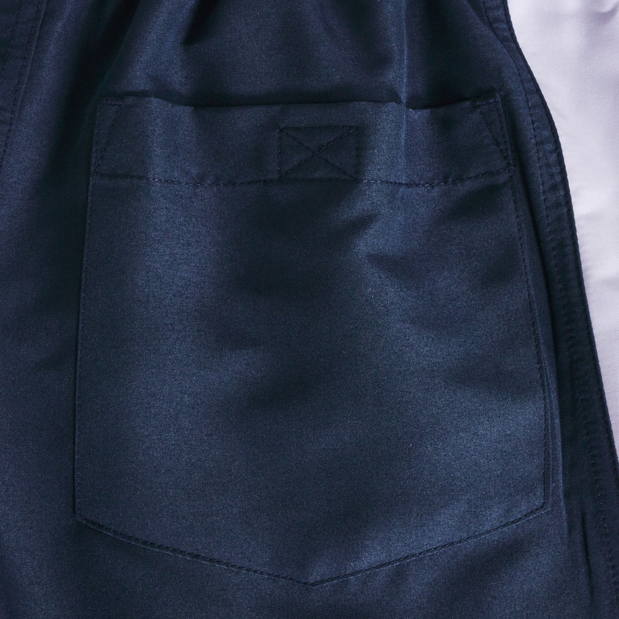 Close-up of a dark blue fabric pocket with visible stitching on the Women's Fundamentals 5" Panel Tactic Shorts by Canterbury.