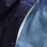 Close-up of a seam on Canterbury's Fundamental Harlequin Drill 3" Shorts, showing navy blue and light blue cotton panels stitched together with a visible white inner lining.